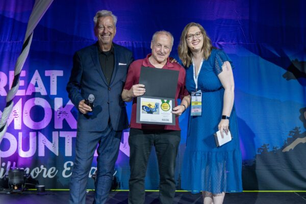 Plein Air Publisher Eric Rhoads and Plein Air Salon MAnager Kari Stober presenting the PleinAir Salon Annual Award of Honorable Mention To Davis Perkins who accepted the award on behalf of Timothy Horn