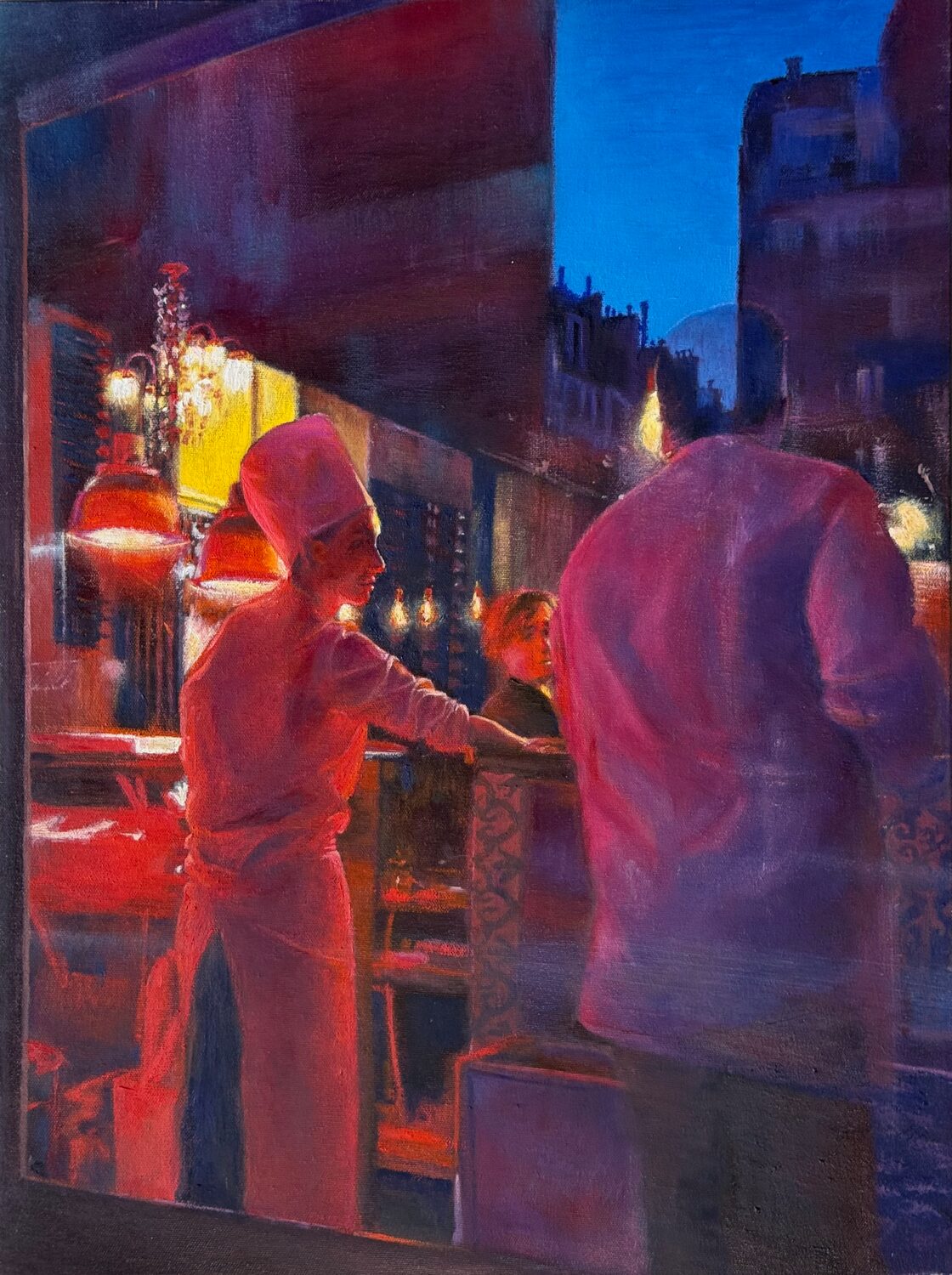 A chef in a white uniform stands in a warmly lit restaurant, talking to a man in a white shirt, with city buildings visible outside against a deep blue evening sky. 15th Annual PleinAir Salon Art Competition