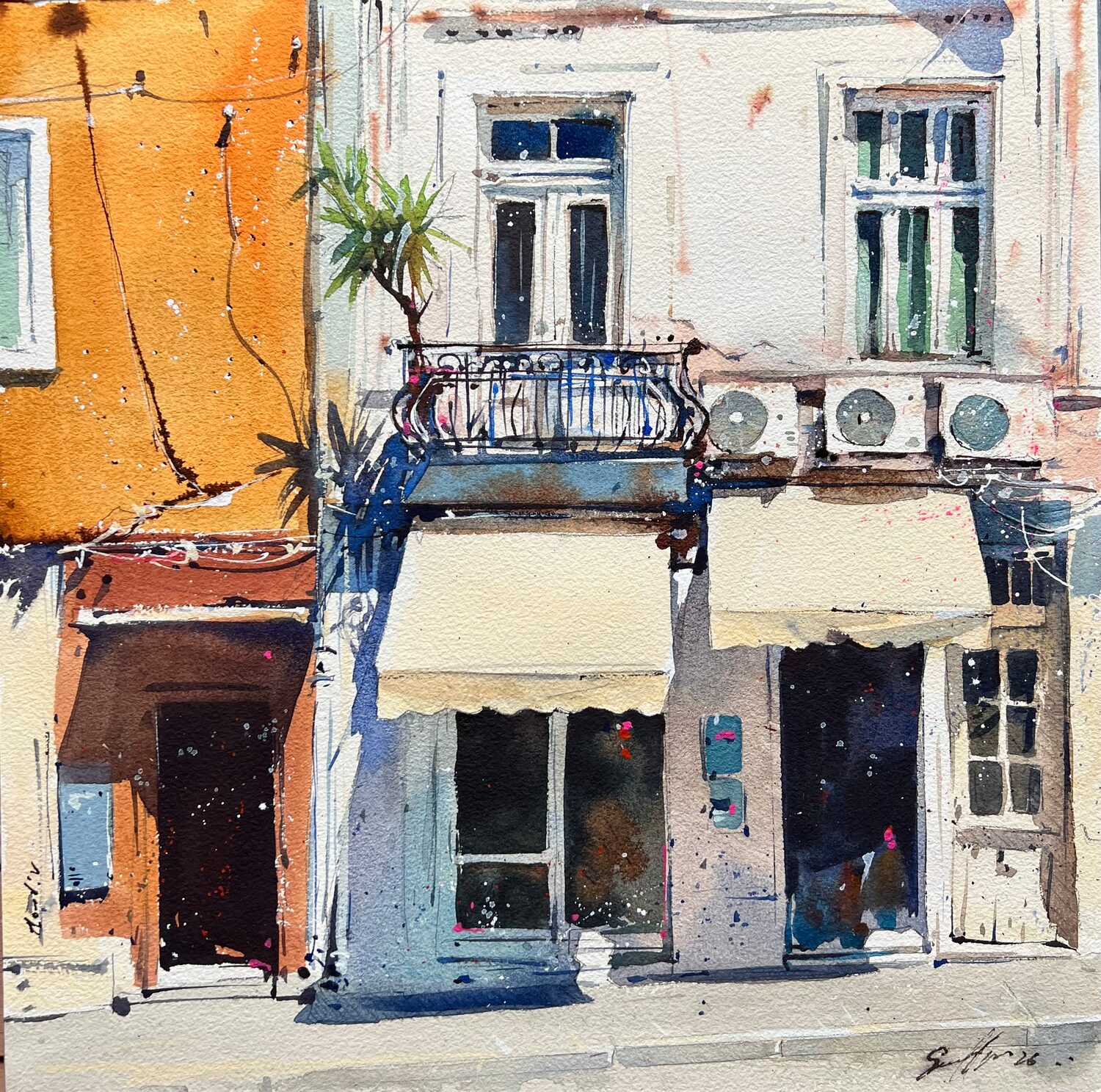A watercolor painting shows a sunlit street with orange and white buildings, balcony, potted plant, air conditioners, and awnings over storefronts. Shadows and splashes of color create a lively, warm atmosphere. 15th Annual PleinAir Salon Art Competition