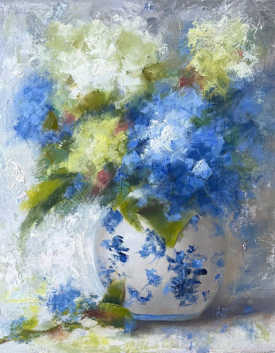 A painted vase with blue floral designs holds a bouquet of blue, white, and yellow flowers, with green leaves and a soft, blurred background. 15th Annual PleinAir Salon Art Competition